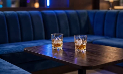 Luxuri&ouml;se Lounge-Sitzecke mit Kristallgl&auml;sern und blauer Neon-Stimmung f&uuml;r Casea Weekend Reload