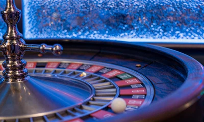 Europ&auml;isches Rouletterad in Bewegung mit blauer Ambient-Beleuchtung im Casea Live Casino